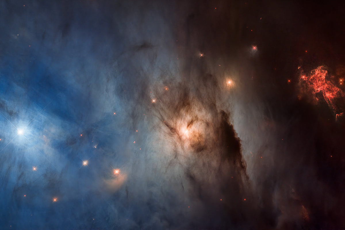 NGC 1333 star-forming region in the Perseus molecular cloud — Hubble Space Telescope 33rd anniversary image 2023 showing a vertical gradient of blue, gold and red gas with newborn stars and dark dust, 960 light-years away